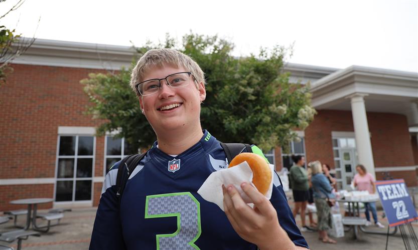 A boy holds up a donut